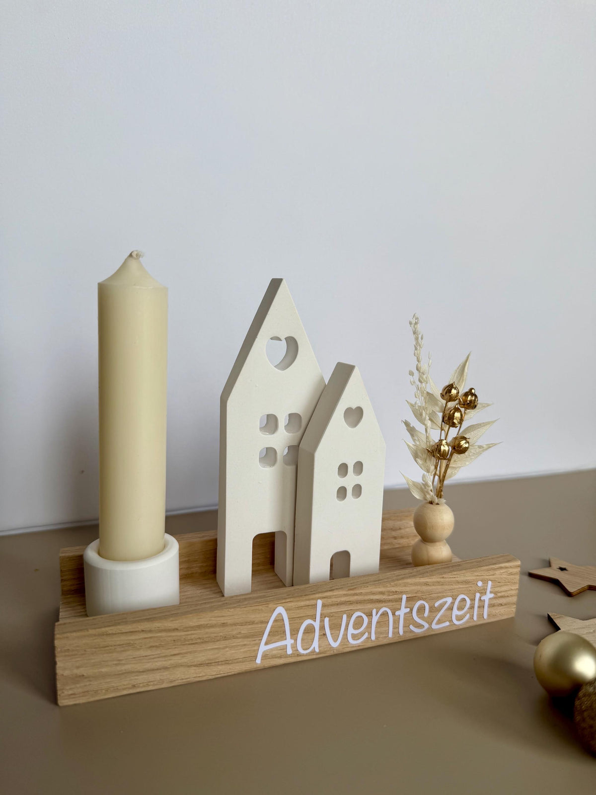 Weihnachtsdorf mit elfenbeinfarbener Kerze und Schriftzug Adventszeit