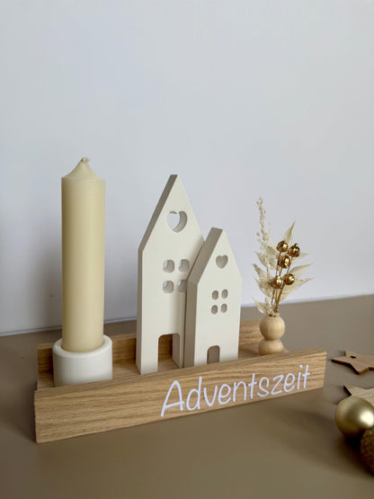 Weihnachtsdorf mit elfenbeinfarbener Kerze und Schriftzug Adventszeit