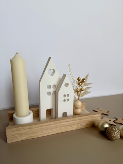 Minimalistische Weihnachtsdeko mit heller Kerze, Häusern und goldenen Trockenblumen