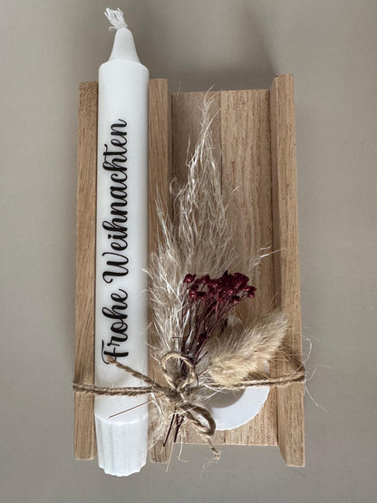 Weihnachtsgeschenk mit Spruchkerze und roten Trockenblumen